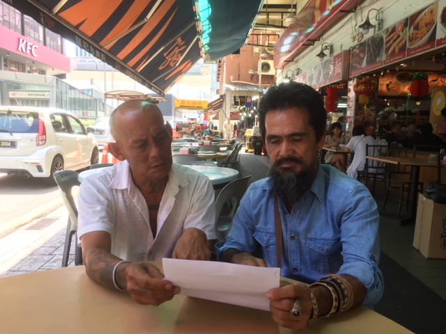 Sunabong Anak Sampai (right) shows Peter John his papers whilst taking part in the delegation to KL